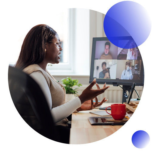 Woman talking animatedly on a Zoom call. Screen is visible with four people on call.